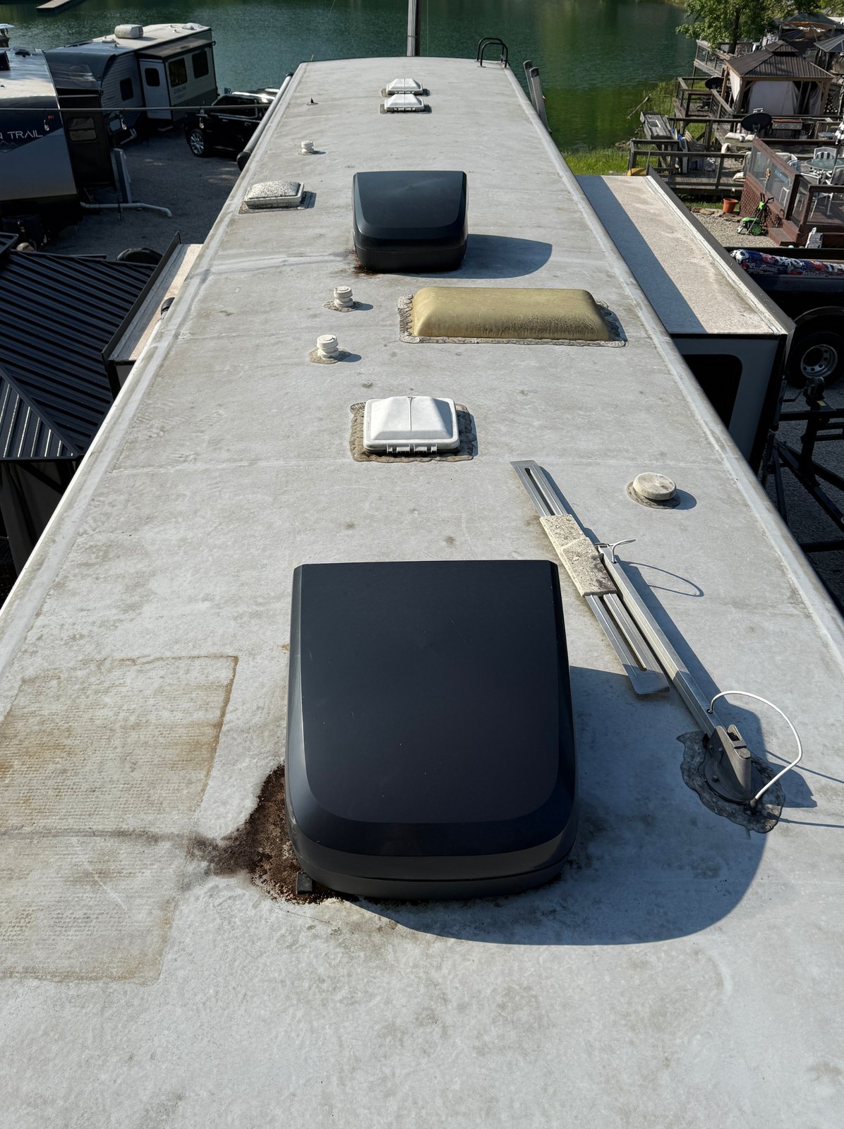 RV roof before: weathered, stained membrane with a rotting seam around the A/C