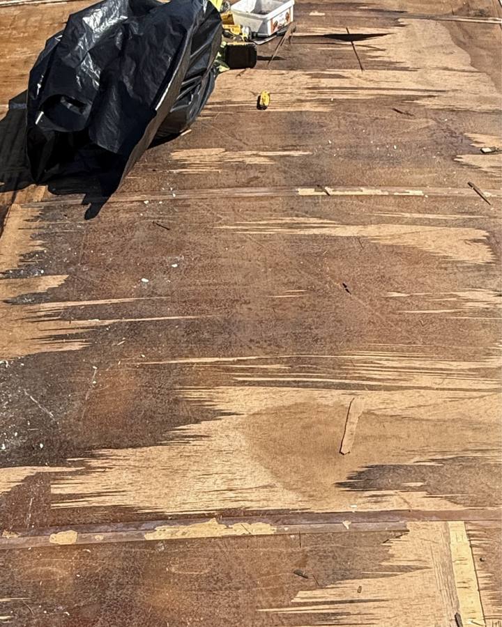 Damaged, water-stained roof decking exposed during repair